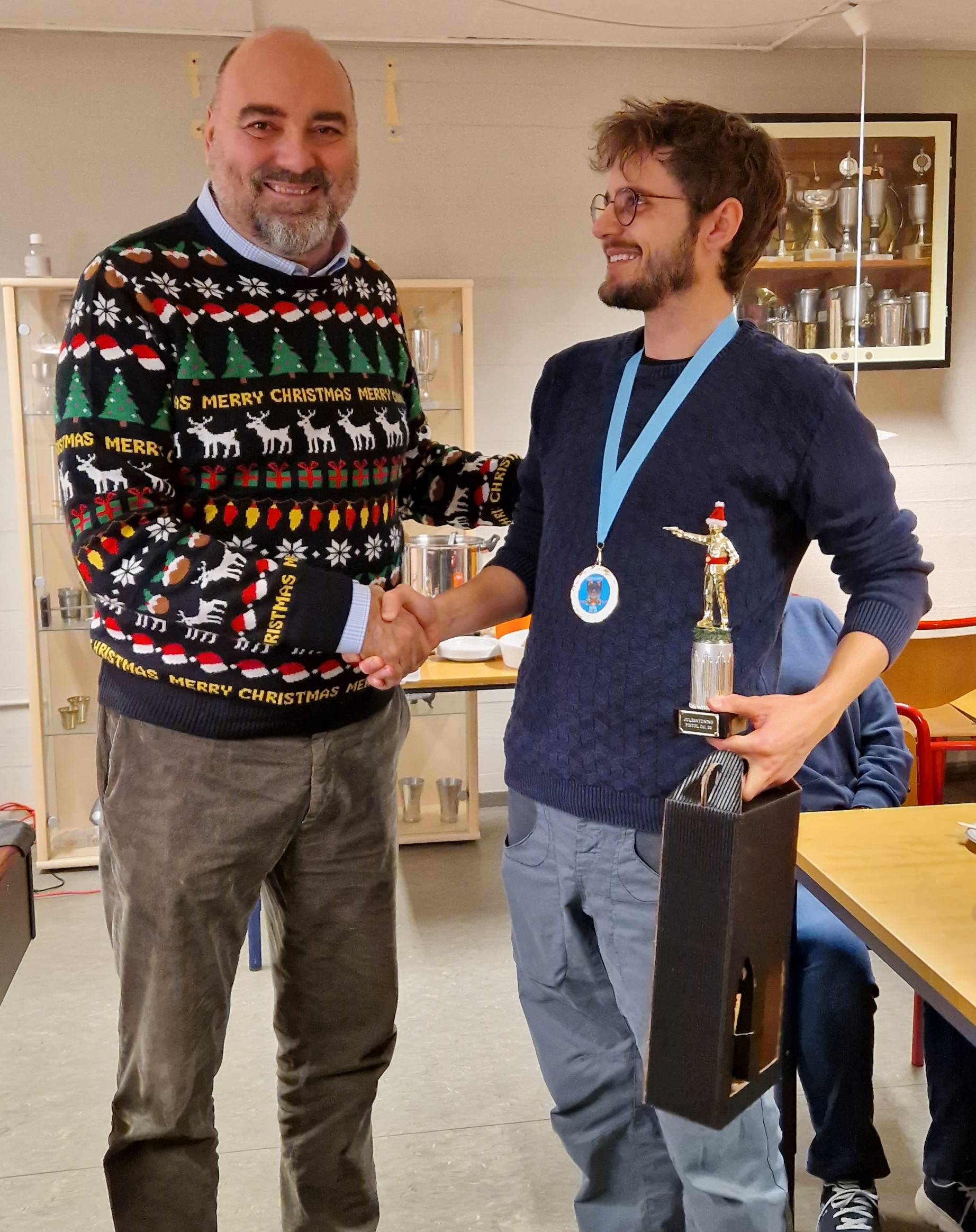 Simon blev vinder af pistol cal.22-juleskydning. Morten overrækker præmierne.